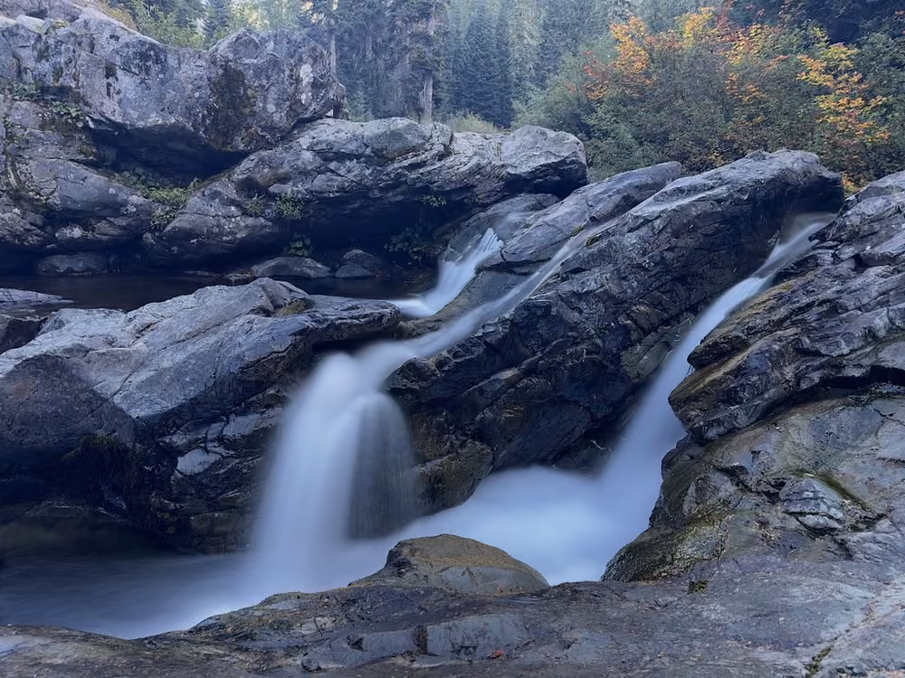 A waterfall pouring between granite boulders