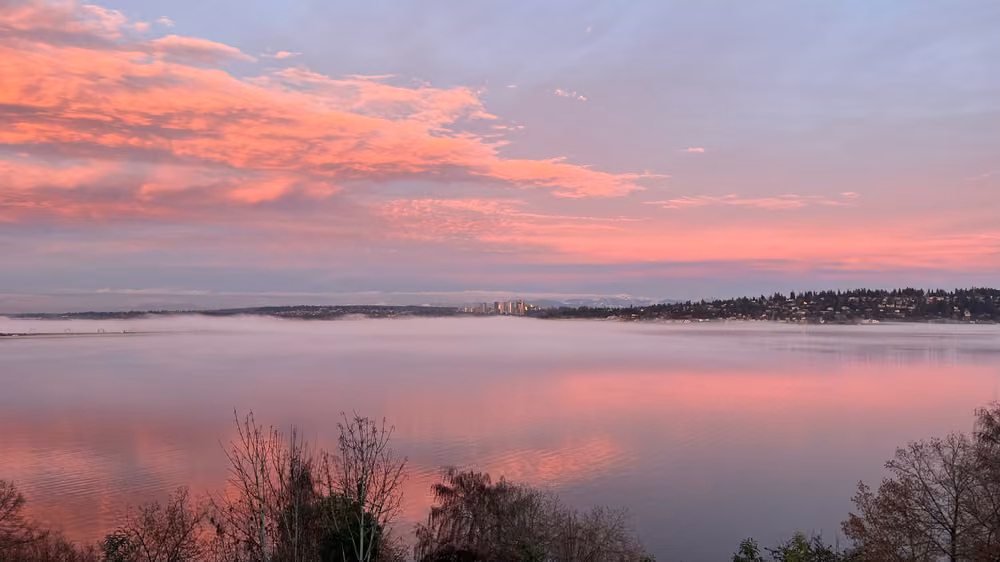 Pink clouds reflected in a calm bay